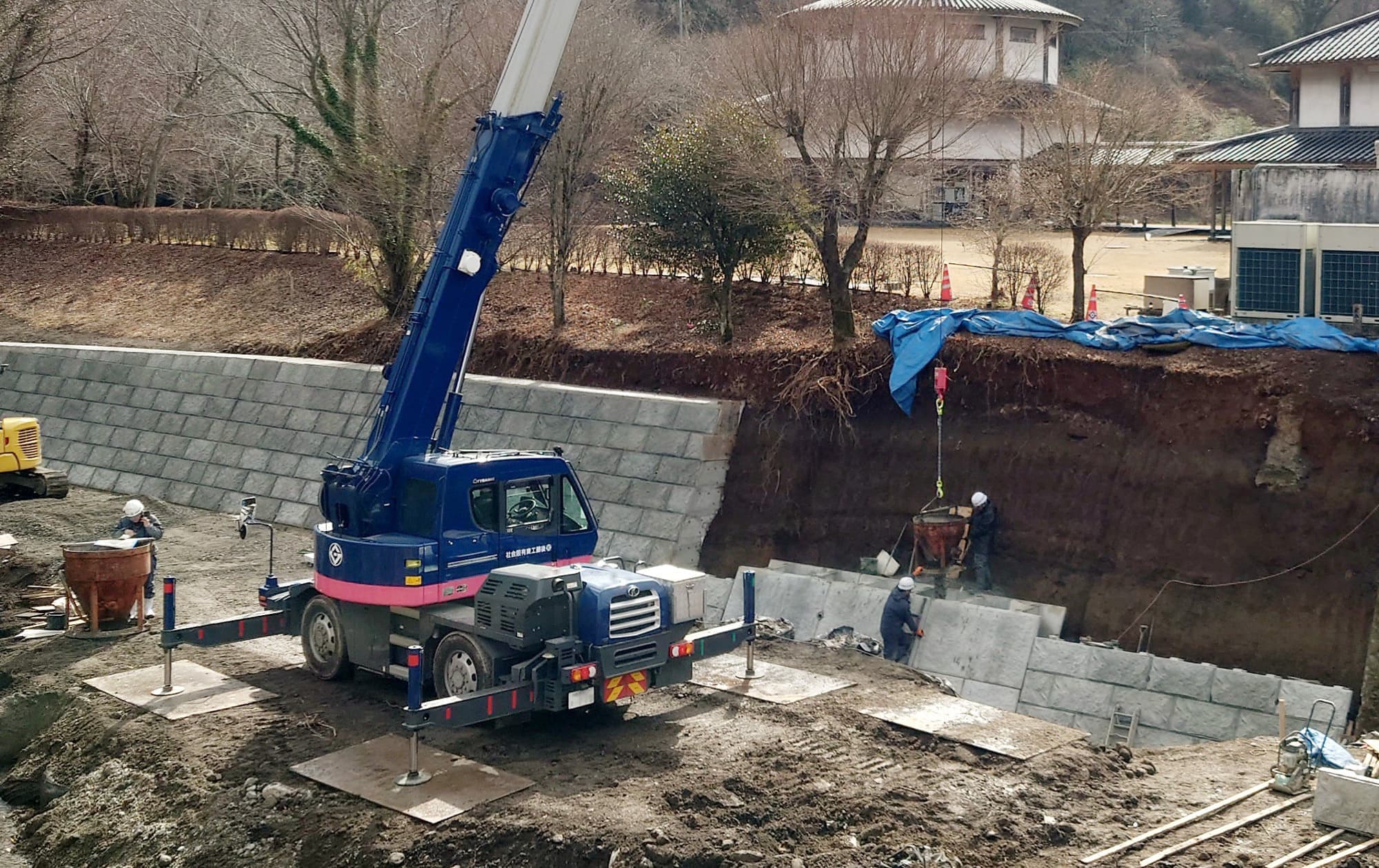 工事の様子。青い重機と黄色の重機を使って工事している写真