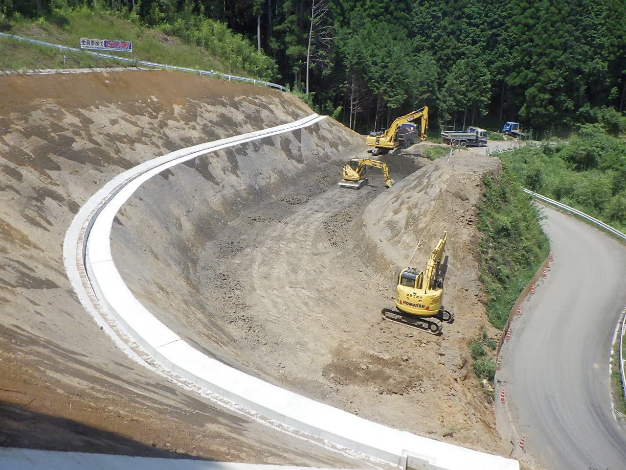 道路工事の様子、黄色の重機を使って工事をしている写真