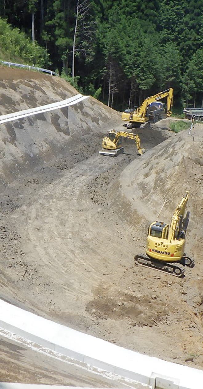 道路工事の様子、黄色の重機を使って工事をしている写真